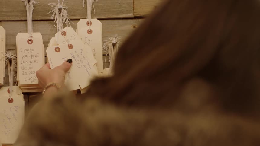 A woman pulls white tags on the wall