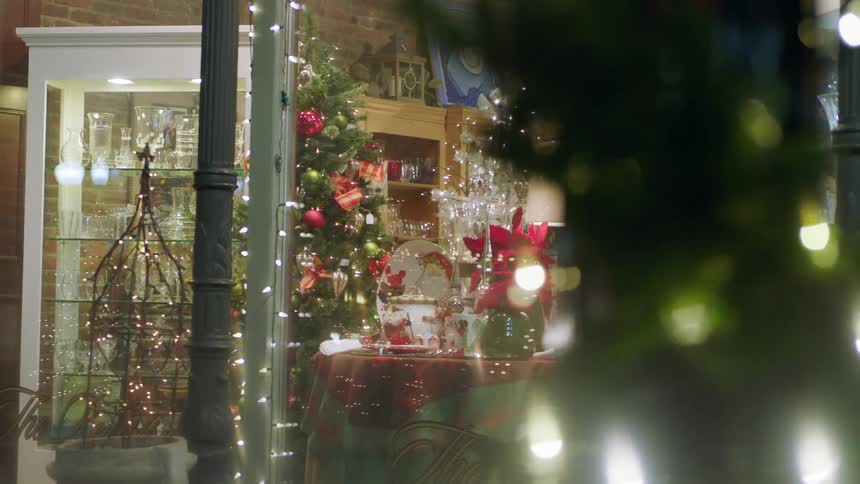 Christmas garland and lights decorate a shop and street lights