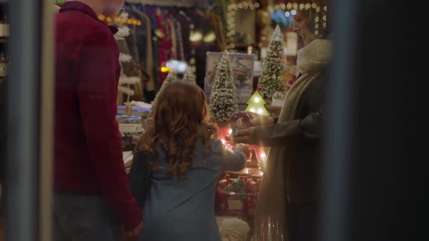 A woman and children look at a snow globe inside