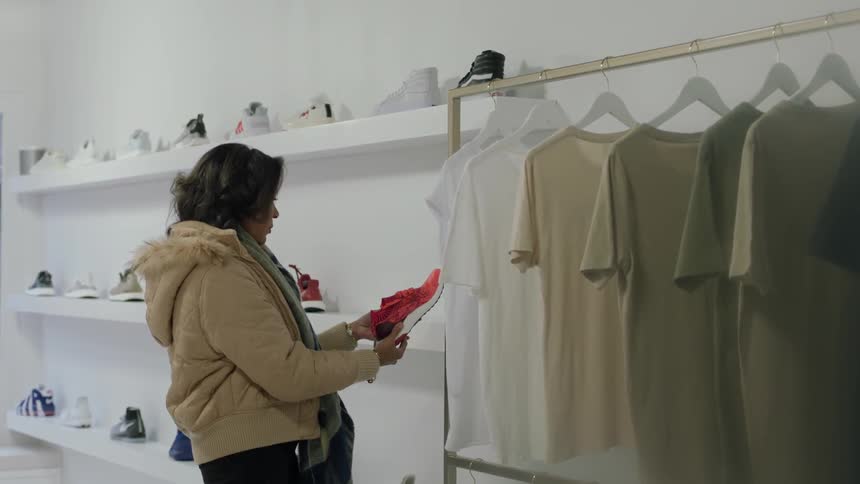 A woman is checking out a sneaker in a shop