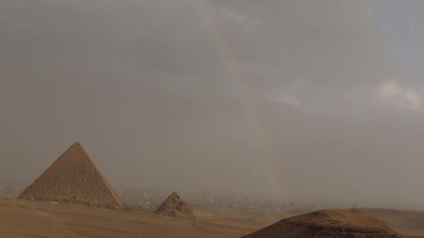 A rare rainbow appears over the ancient Egyptian pyramids during a stormy day in the desert