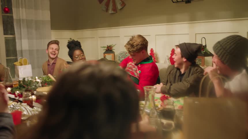 A group gathers around a dining room table to celebrate christmas