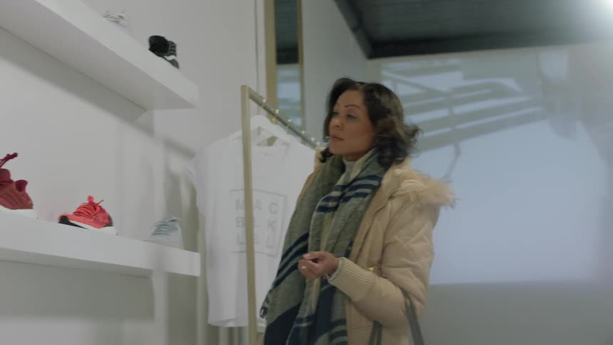 A woman shops for sneakers in a store
