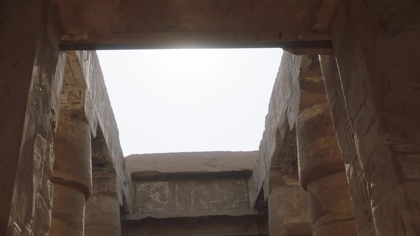 Sunlight streams through the open roof of an ancient Egyptian temple as the camera pulls back