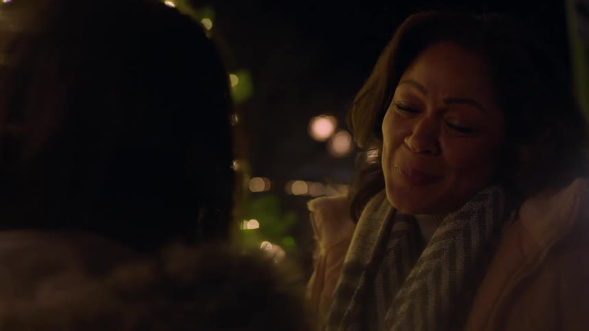 Two women talk and look at a christmas tree