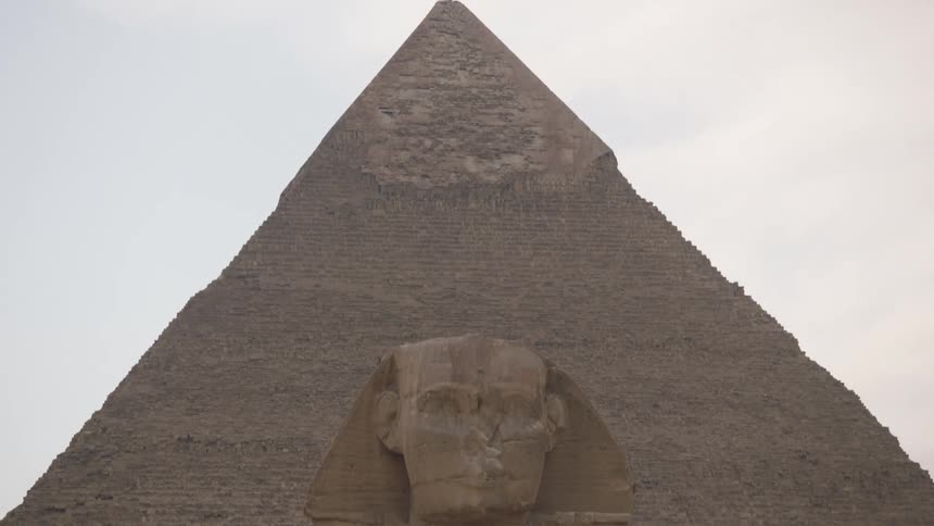 Tilt-down shot from the sky revealing the Great Sphinx with the Pyramid of Khafre behind it in Giza, Egypt