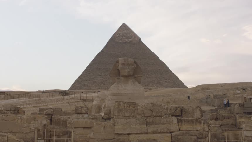 The Great Sphinx of Giza stands majestically before the Pyramid of Khafre on a bright, overcast day in Egypt