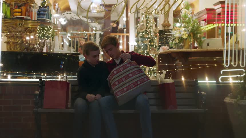 Two boys are looking at gifts they've bought while shopping