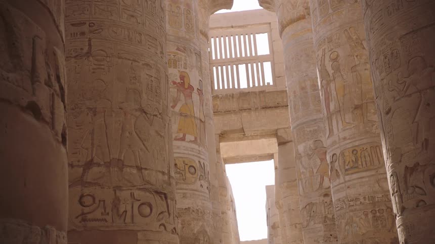 Majestic columns with ancient hieroglyphics are revealed as sunlight floods an Egyptian temple