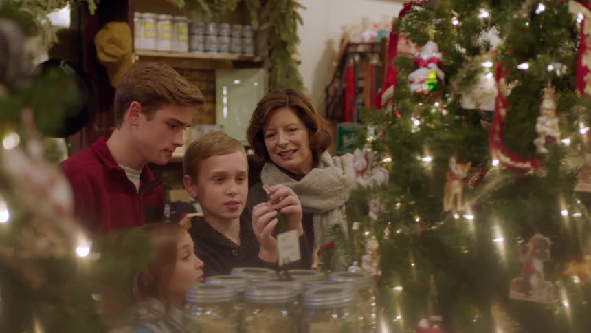 A grandmother and her grandchildren look at items in a shop