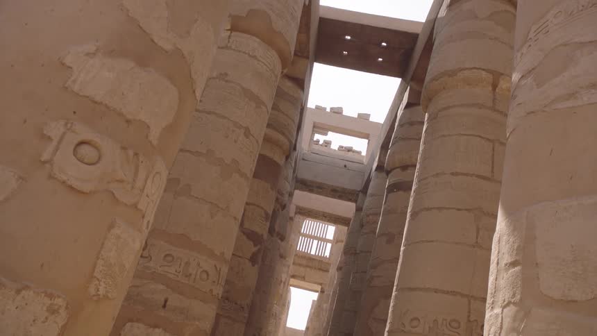 Sunlight illuminates the majestic, hieroglyph-covered columns in the Great Hypostyle Hall of the Karnak Temple in Luxor, Egypt