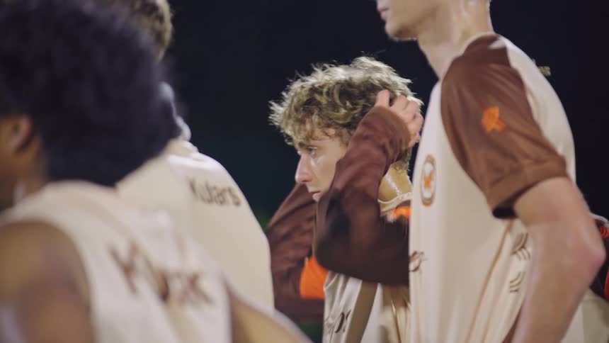 A distraught young male soccer player runs his hands through his hair and cries in frustration after a tough game