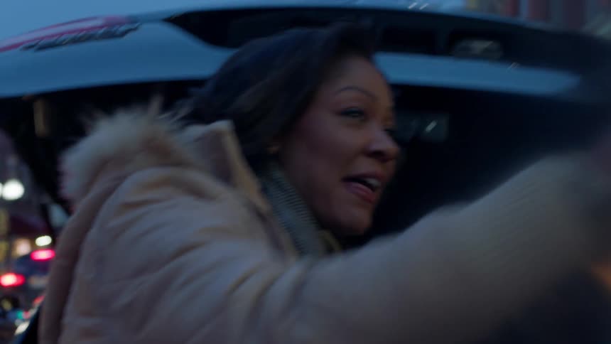 Two women put items in their car and walk towards a shop