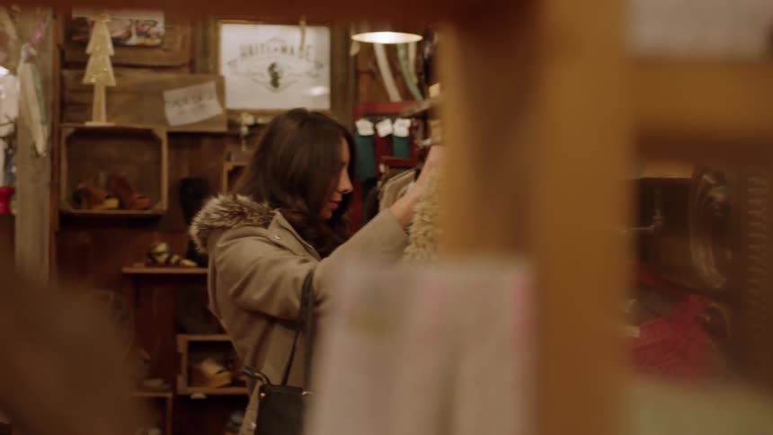 A woman looks at clothes for sale in a store