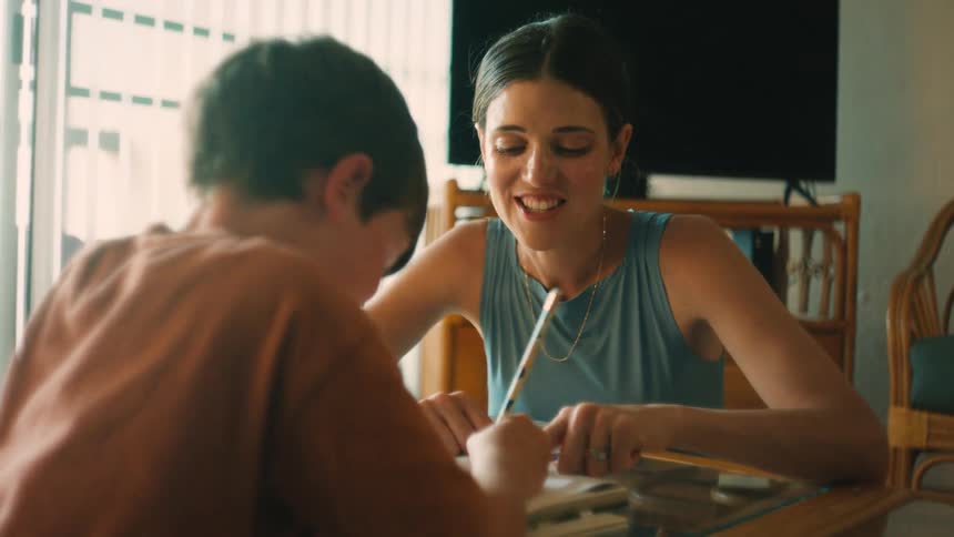 A loving mother helps her son with homework, sharing a happy and supportive moment at home