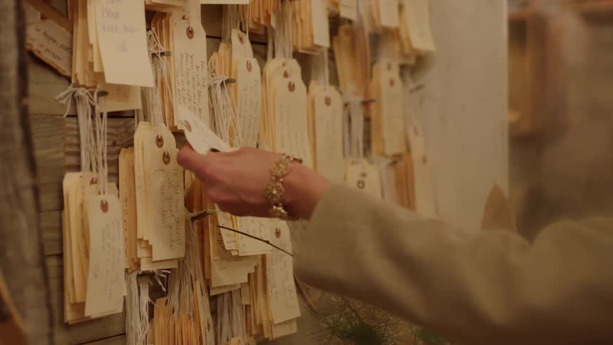 A woman looks at tags hanging on the wall of a retail store