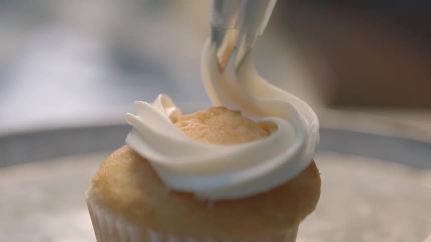 Frosting is put on a muffin
