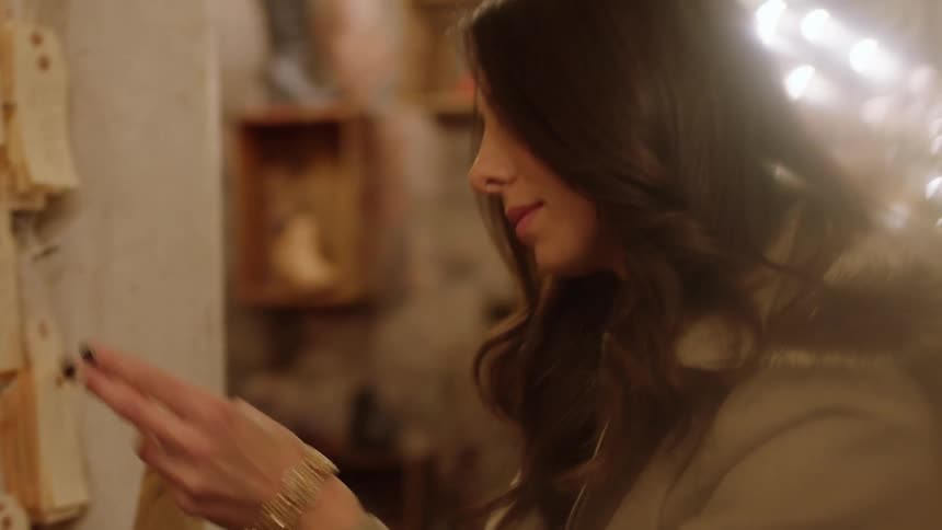 A woman picks up and reads a gift tag while shopping