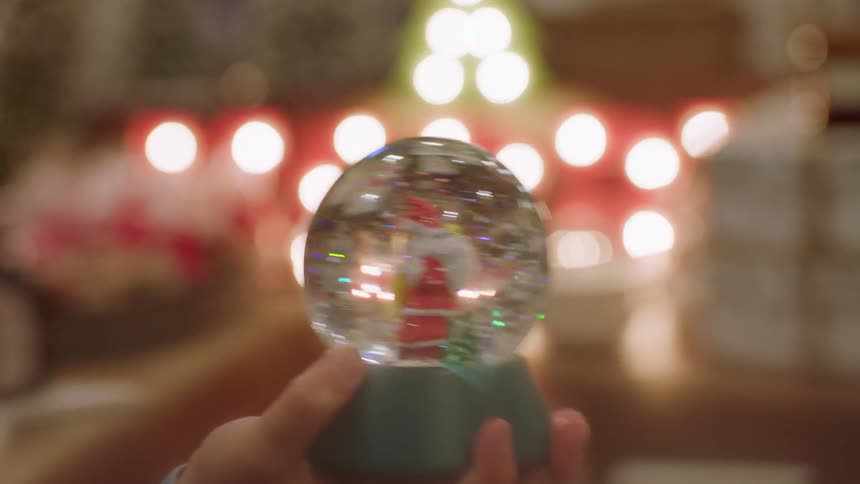 A person shakes a snow globe
