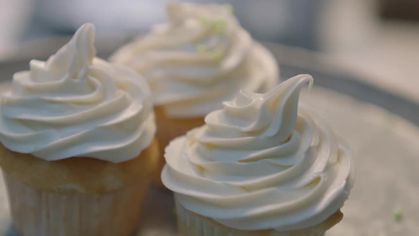 Sprinkles are poured on the cupcakes