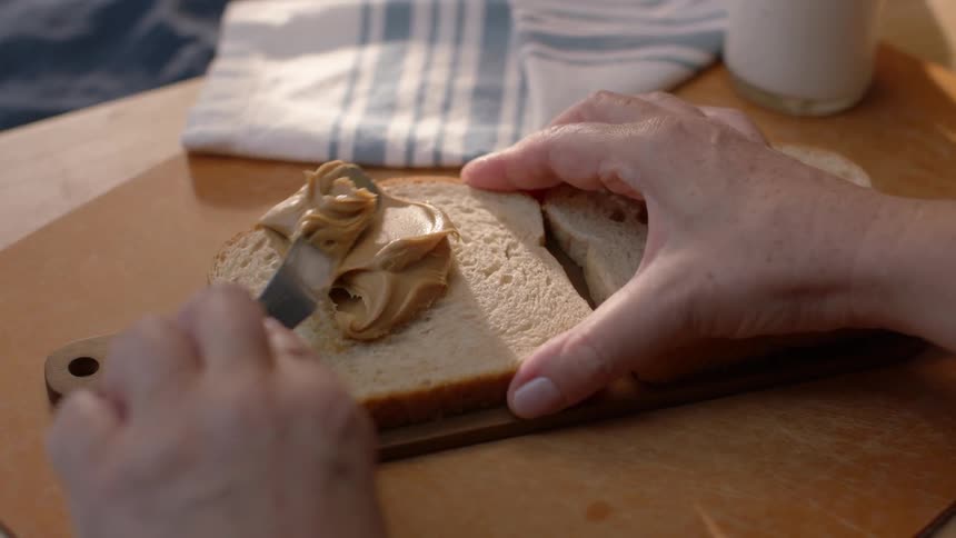 Peanut butter is put on some bread