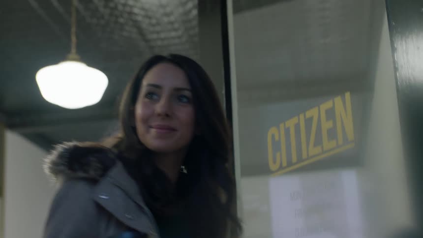 Smiling woman holding gift bags walks out of store