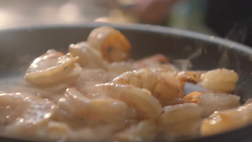 Shrimp being tossed and cooking in frying pan