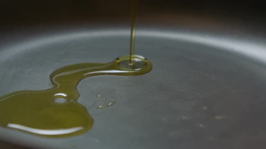 Cooking oil pouring into frying pan
