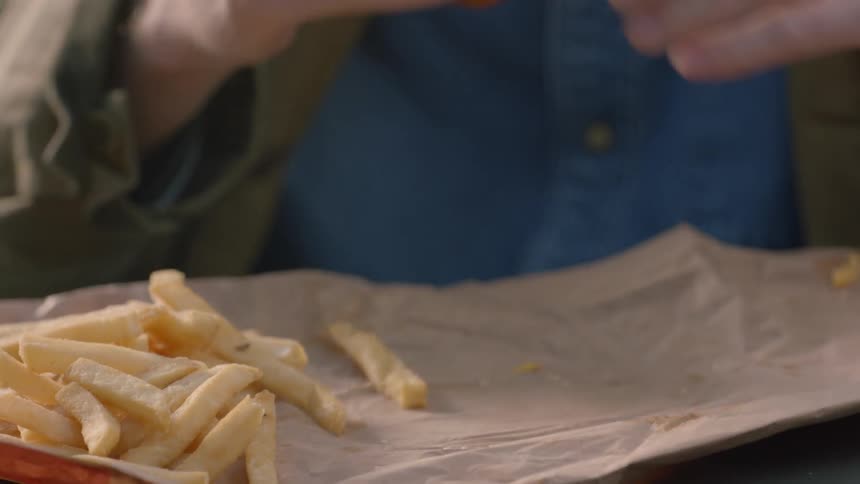 A man lifts a burger to take a bite