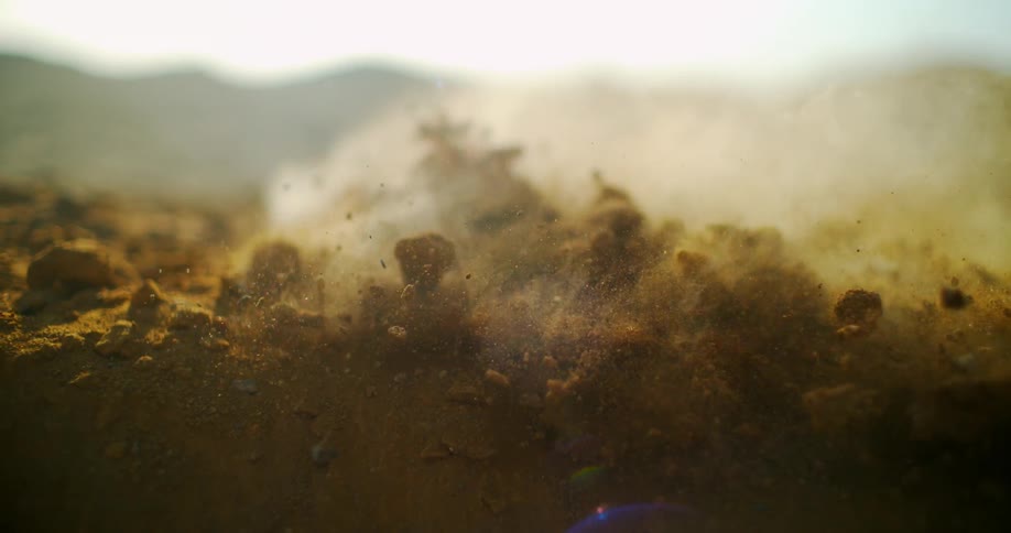 Dirt hits the ground and generates dust