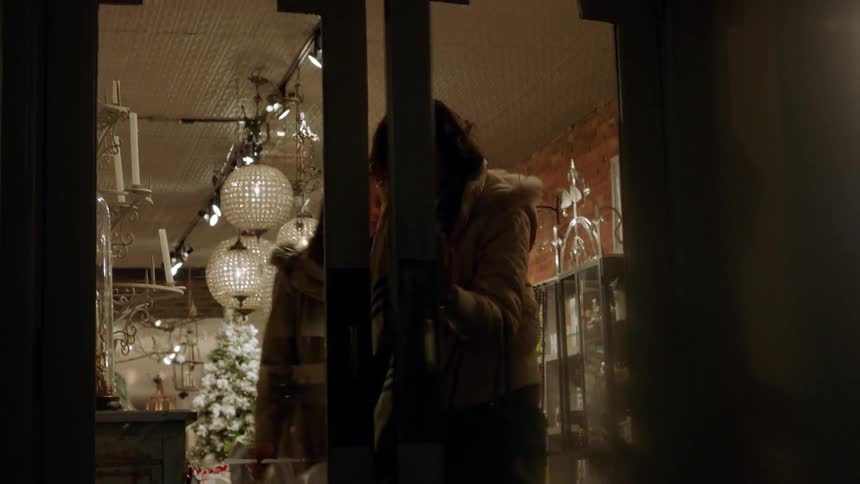 Two women exit a shop at night