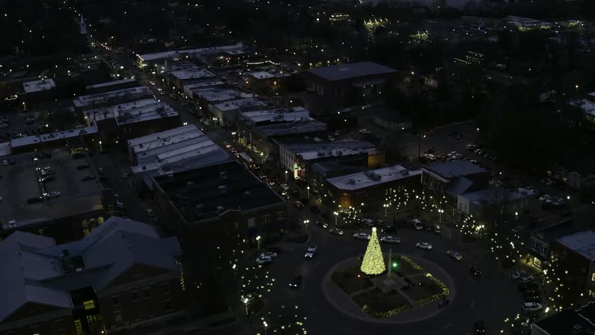 Lighted christmas tree outdoors at night in a city