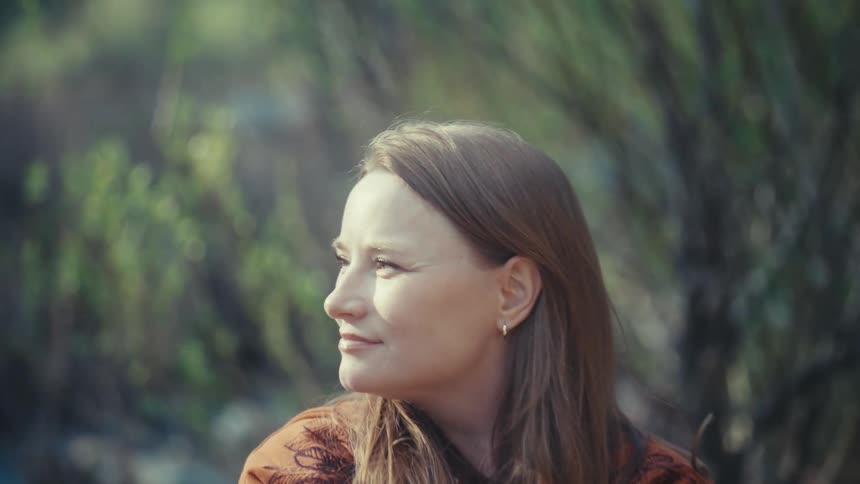 Profile of a beautiful woman with a peaceful smile enjoying a quiet moment in nature