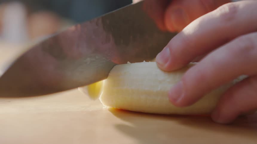 A person cuts a banana