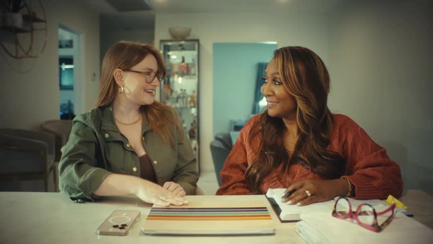 Two diverse businesswomen shake hands, finalizing a deal after a productive meeting on a laptop in a home office