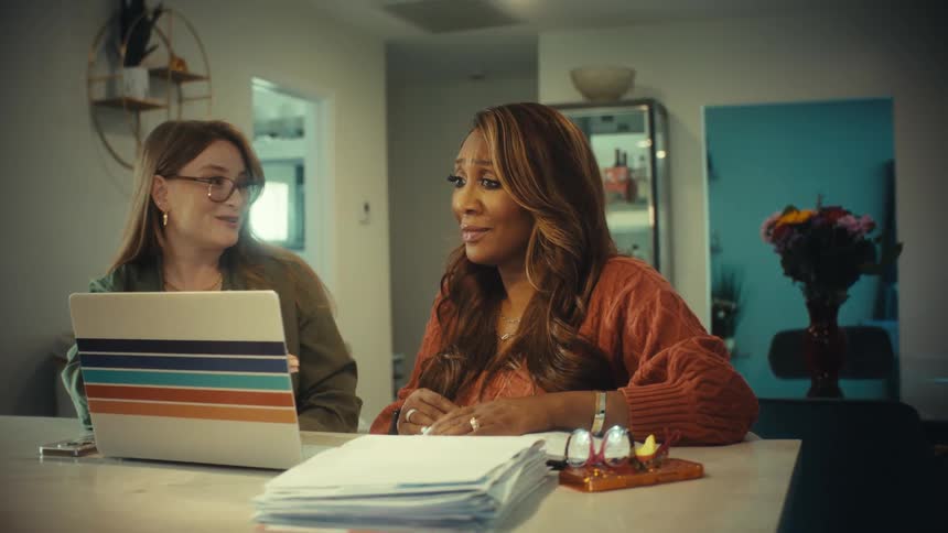 Two diverse businesswomen successfully close a deal with a friendly handshake after a productive meeting with a laptop at home