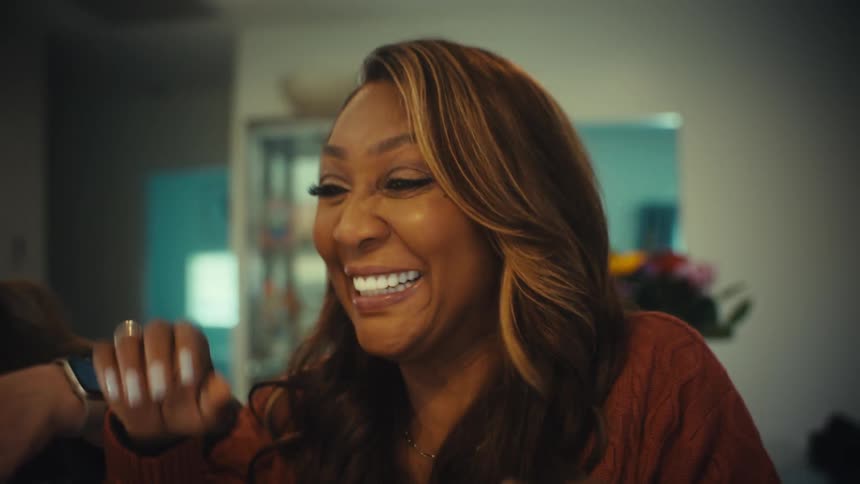 Two diverse female entrepreneurs erupt in joyous laughter and celebrate a major success together while working on a laptop from a home office
