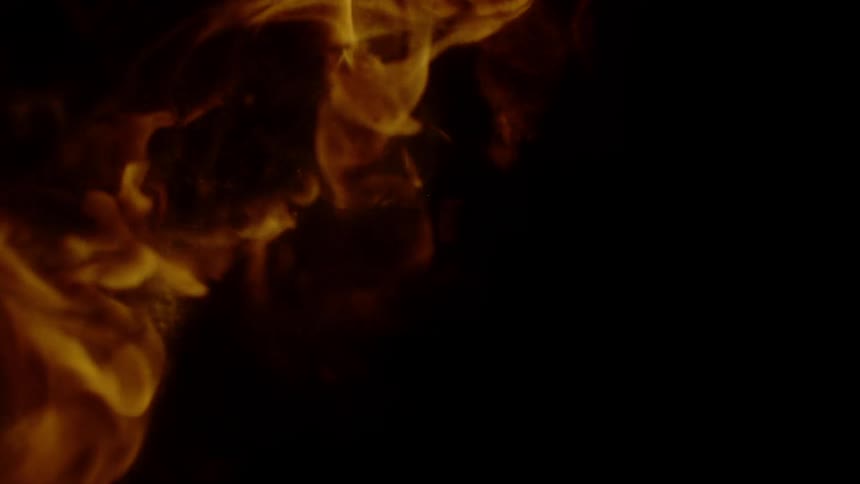 A flame flares in the dark