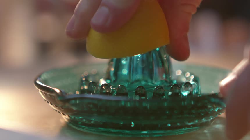 A lemon is squeezed into a dish