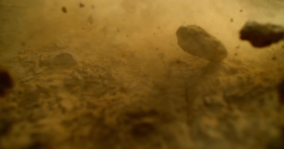 The rocks and dirt fly forward on the field