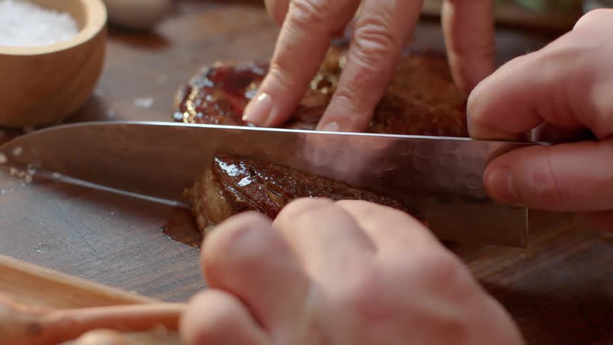 A man slices a piece of cooked meat