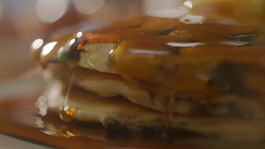 Syrup drips down the sides of pancakes