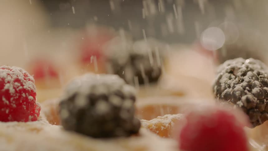 Powdered sugar is poured on the fruit of the waffles