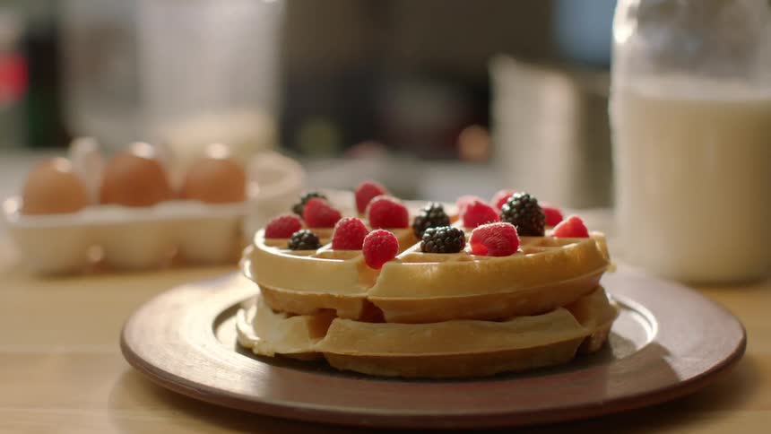 Berries cover a stack of homemade waffles