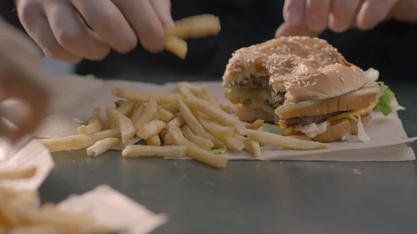 A man eats a burger and fries