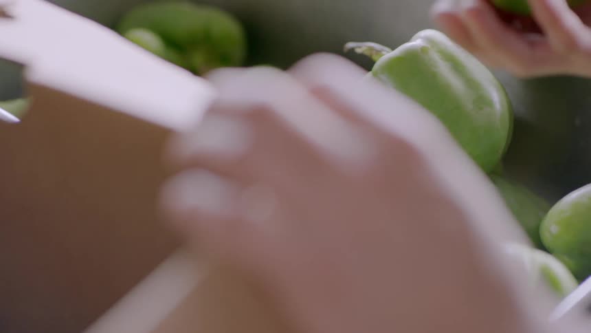 A person puts peppers into a bin