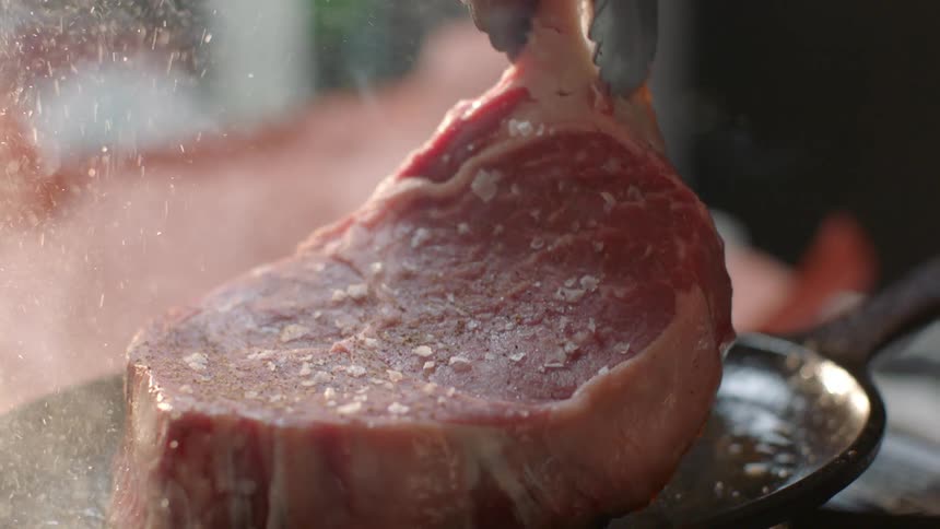 A steak is cooking on a small pan