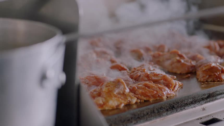 Meat is cooking on a large grill