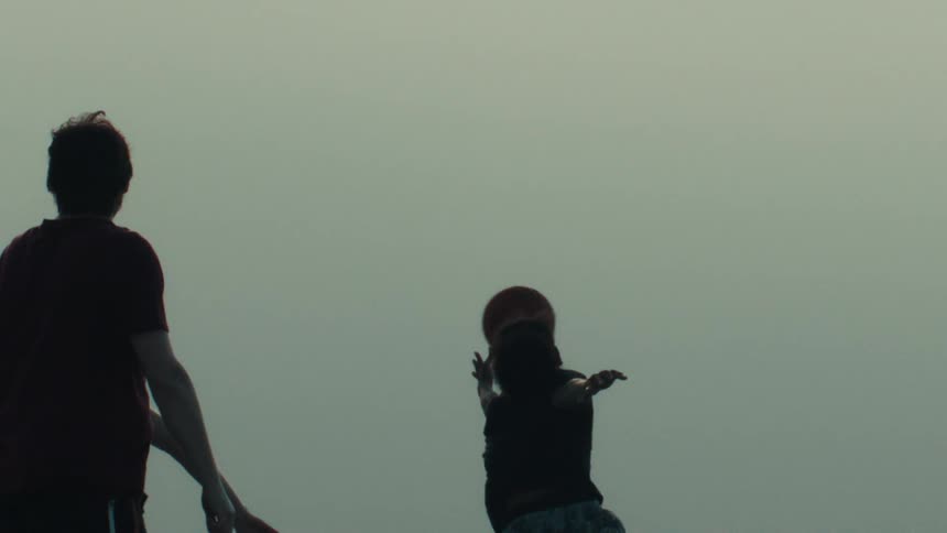 A silhouetted man passes a basketball to his teammate in super slow motion