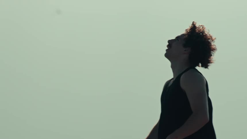 A basketball player's jump shot is captured in dramatic slow-motion silhouette as his friends look on